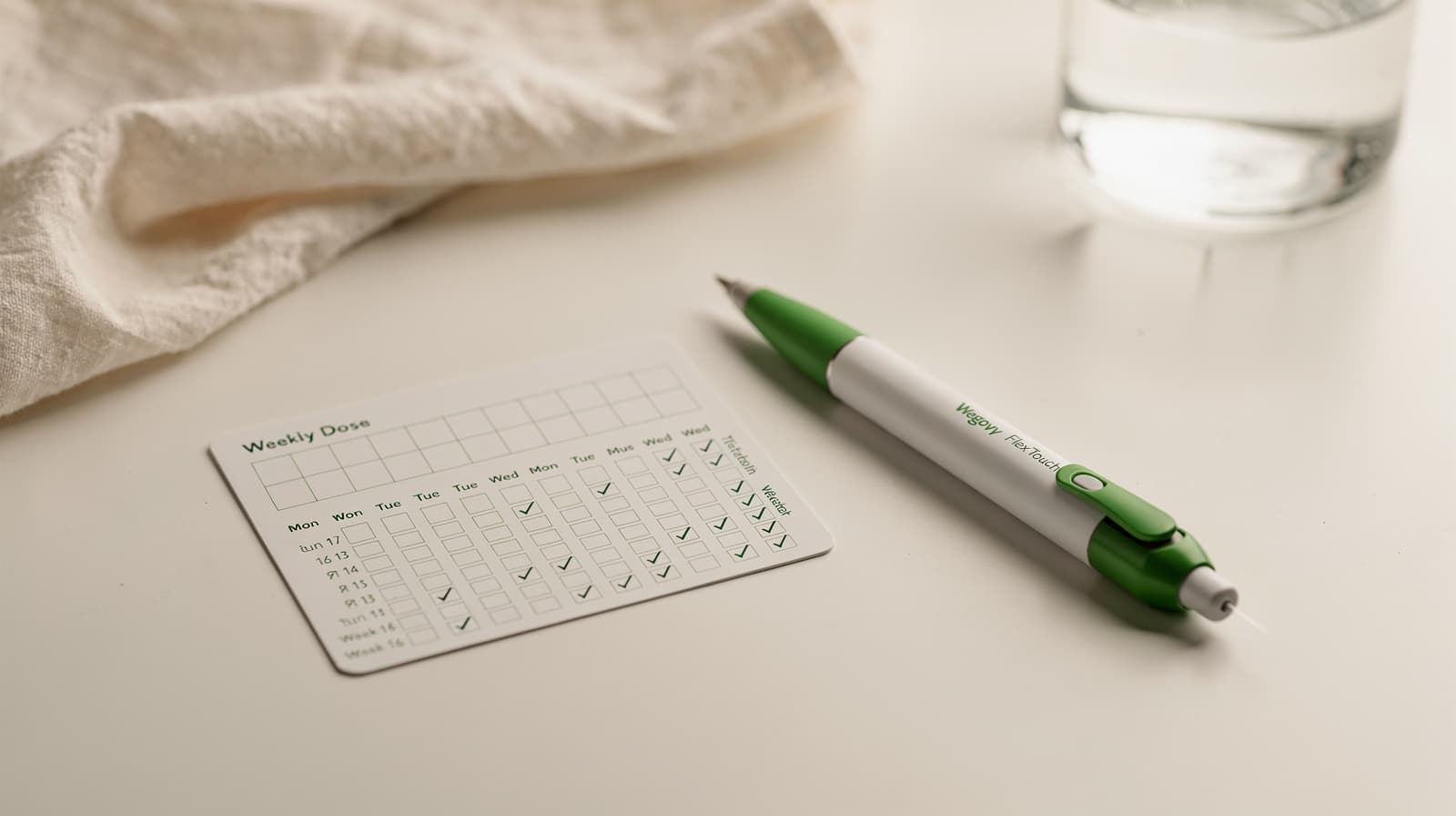 Wegovy FlexTouch pen on a clinical white surface beside a weekly dose tracker, illustrating the 16-week titration schedule.